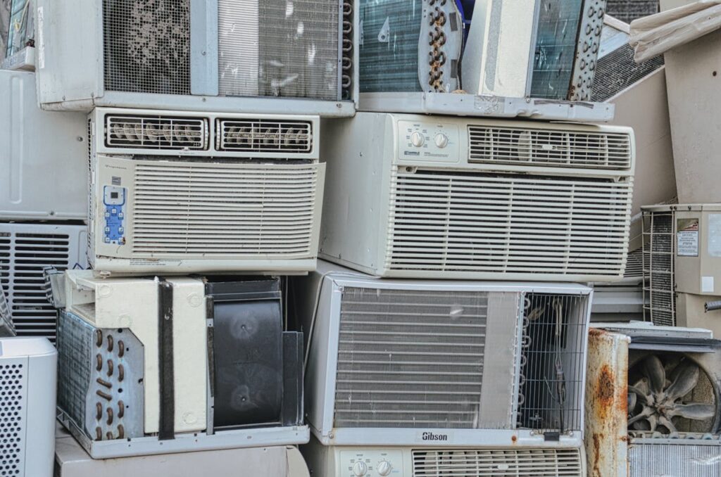 pexels photo 11256545 A pile of old window air conditioners awaits recycling, illustrating electronic waste issues.